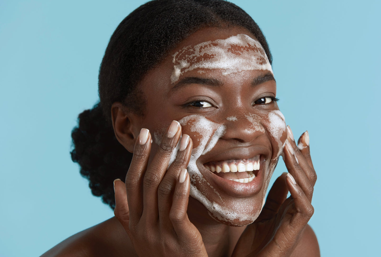 Model applying foaming cleanser, representing Moirai Blue Tansy & Matcha Nourishing Gel Cleanser