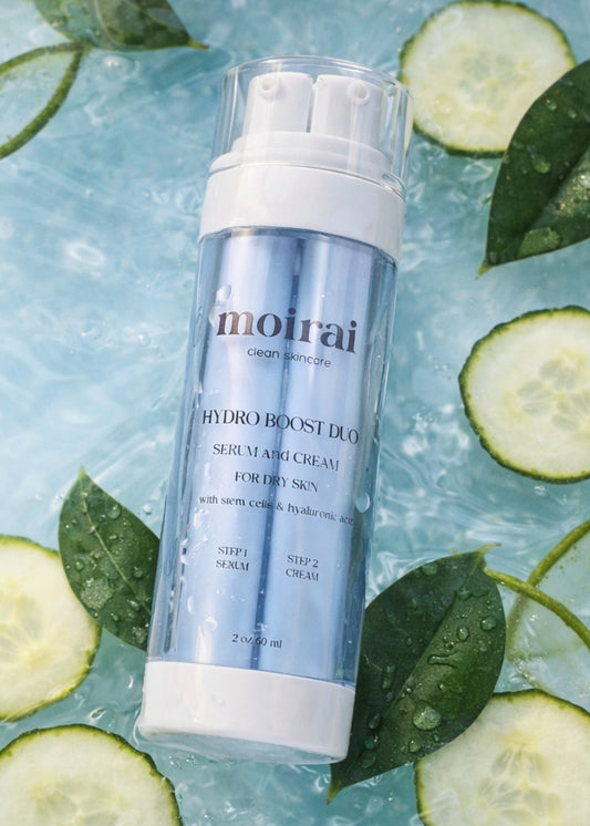 Moirai Hydro-Boost Duo dual-delivery hydrating serum and cream for dry skin with cucumber slices, green tea laves and water background