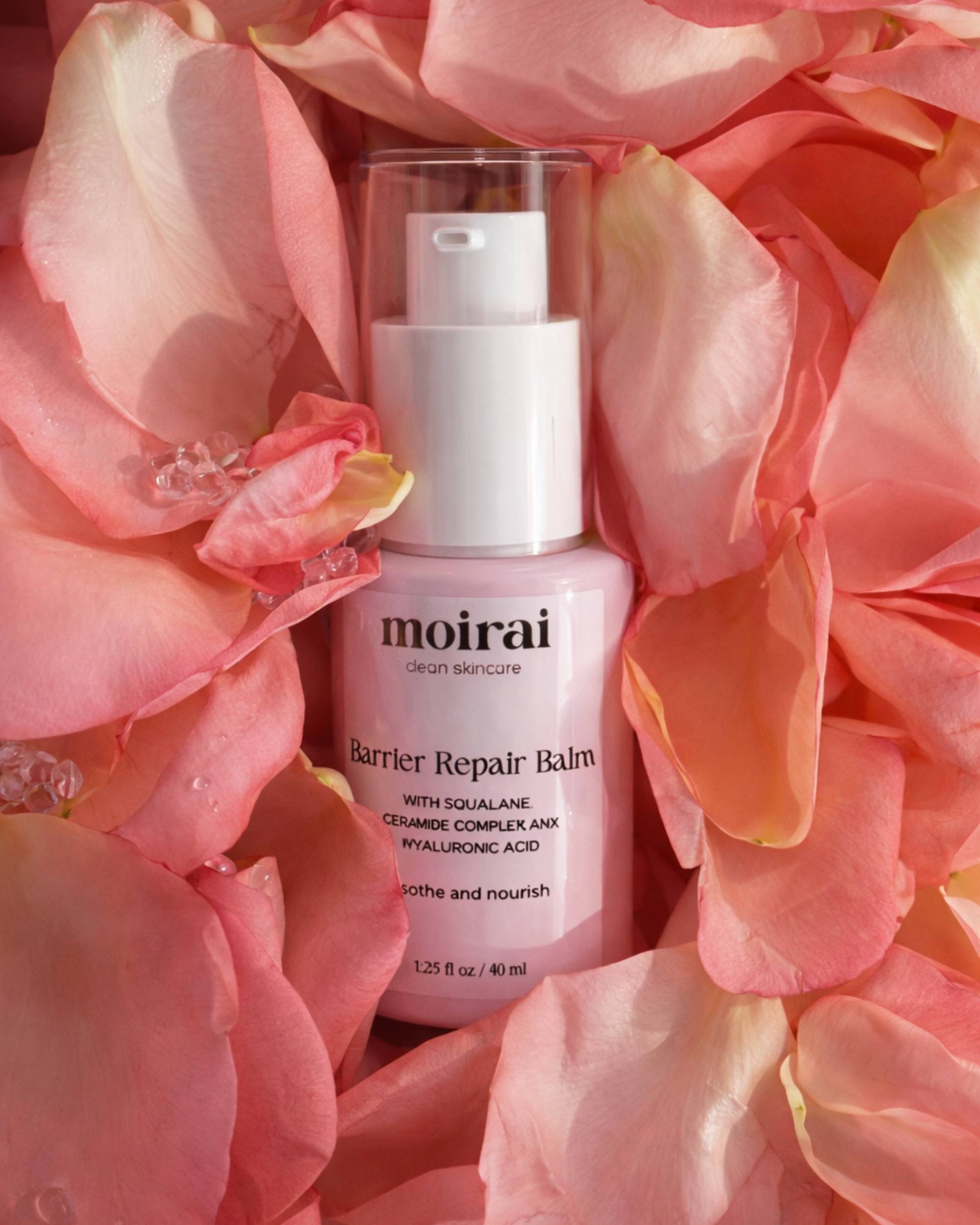  Moirai Skincare Barrier Repair Balm pink bottle with squalane surrounded by rose petals