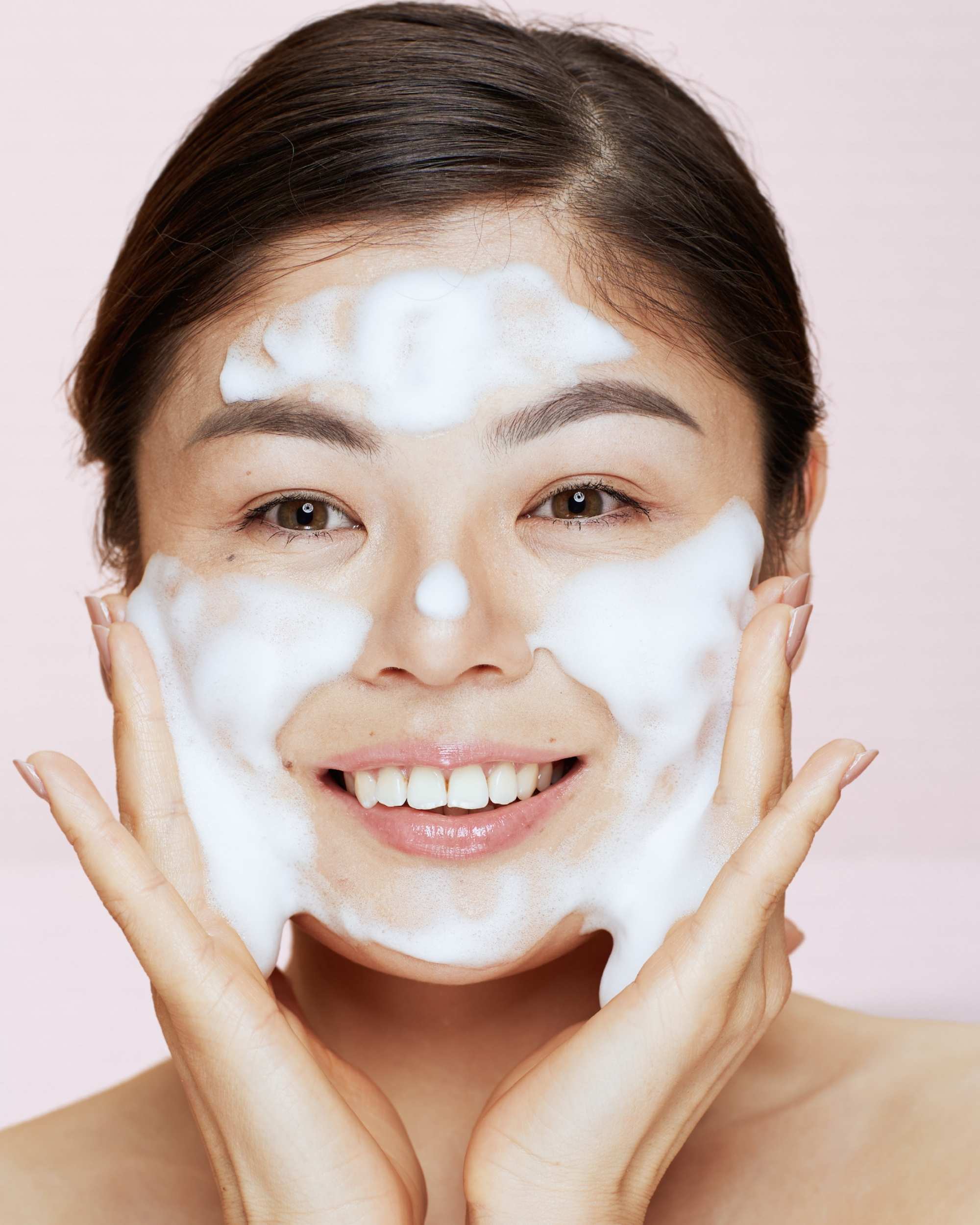 Woman washing face with Moirai Coconut Milk & Honey Gentle Cleanser foam