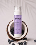 Moirai Peptide Firming Duo serum and cream in one bottle featuring peptides and antioxidants for firmer-looking, hydrated skin, photographed with coconut and blueberries on a luxury skincare background
