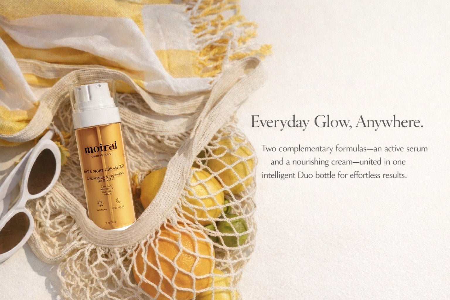 Moisturizing Day and Night dual chamber bottle in a mesh bag with citrus fruits, text 'Everyday Glow, Anywhere.
